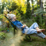 Mature woman relaxing in deckchair in her garden